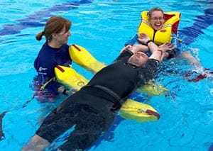 aquatic trainers practising a spinal rescue