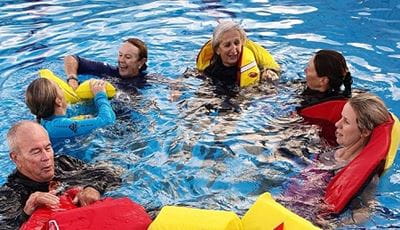 aquatic trainers wearing lifejackets in a pool as part of a training exercise