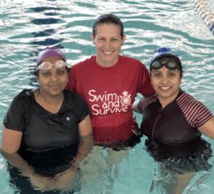 Two multicultural women in the pool with their swim instructor