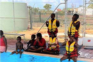 Aboriginal children wearing lifejackets by the pool