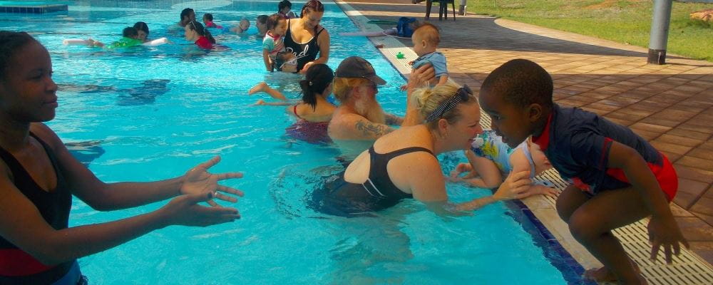 Parents and children in the pool during an infant aquatics lesson at Fitzroy Crossing