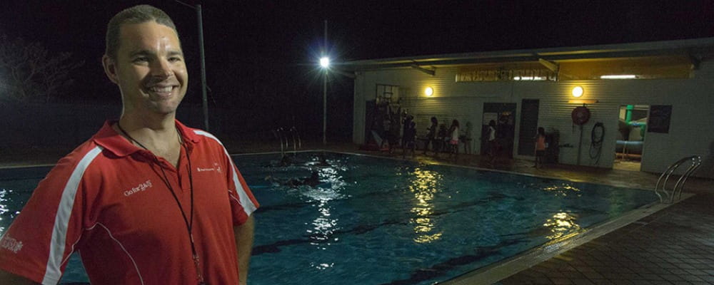 Aaron Jacobs stands in front of the Fitzroy Crossing pool at midnight