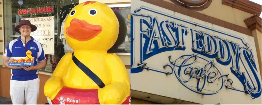 Volunteer Chris with large inflatable Quackers Duck collecting donations outside Fast Eddys alongside Fast Eddys sign