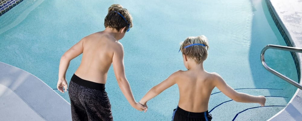 two young boys about to jump into pool