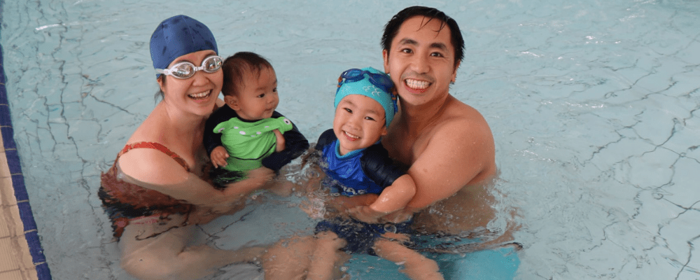 Parents and two children in shallow end of pool