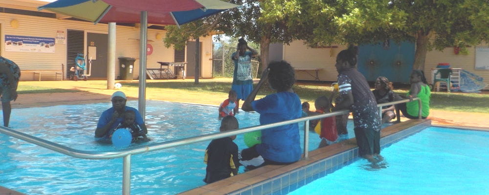 A group of Aboriginal children and parents in the pool at Bidyadanga
