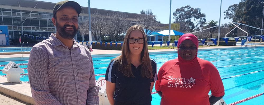 Jasjit Mann from Indian Society WA with RLSSWA's Lauren Nimmo and swim instructor Najma Ahmed by the pool at Terry Tyzack Aquatic Centre