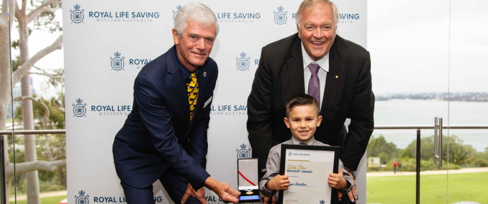Jayce Vassiliou receiving his award from RLSSWA President Colin Hassell and WA Governor Kim Beazley