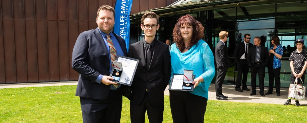 Bravery Award recipients Dan Holman and Marie Macdonald stand with Zac, the young man they saved