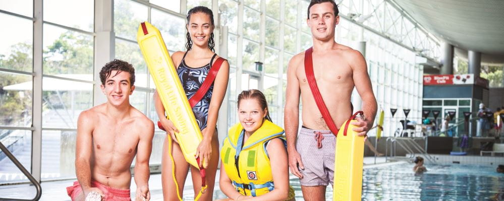 4 teenagers by a pool with lifesaving equipment