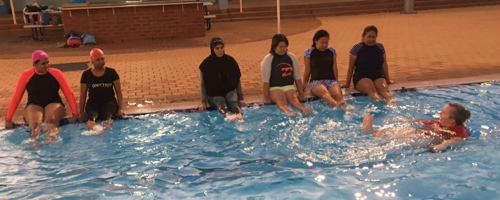 A group of CaLD Swim and Survive participants learn swimming skills in Port Hedland Pool