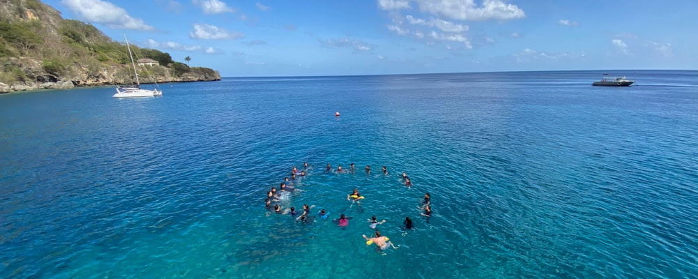 A group of students in a circle in the ocen off Christmas Island