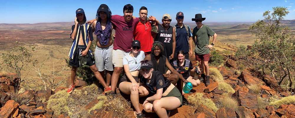group of young Pilbara adults at the top of Mount Bruce