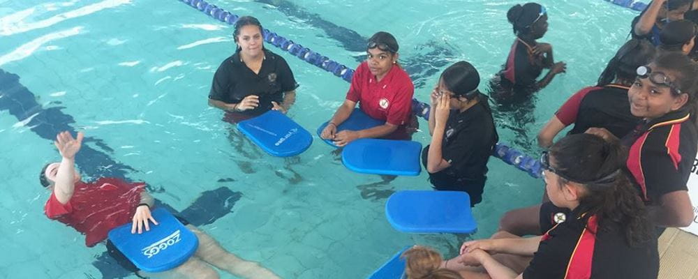 Aboriginal girls in a swimming pool with their instructor