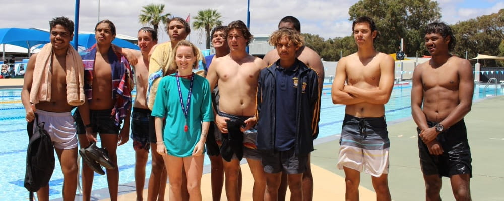 A group of boys from the Clontarf Academy in Geraldton pose by the pool