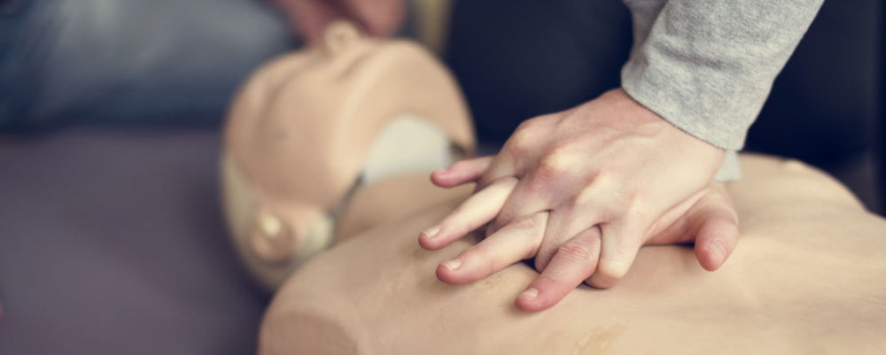 A person prasticing CPR on a manikin