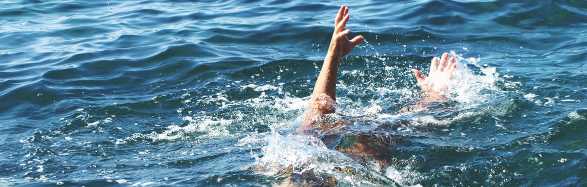 The arm of a drowning victim flails in the water