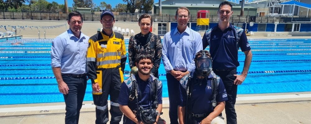 RLSSWA's Travis Doye, DWER Environmental Officer Cheyne Quesnell, Environment Minister Amber-Jade Sanderson, RLSSWA's Peter Leaversuch and Warren Goodwin, with Trainees Mark Corbett and Tom Pearce by the pool at HBF Stadium