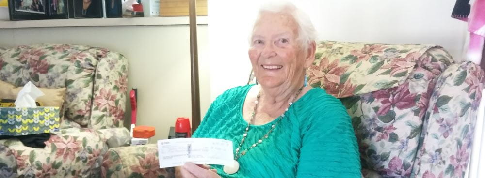 Image of winner Phyllis holding her winner's cheque