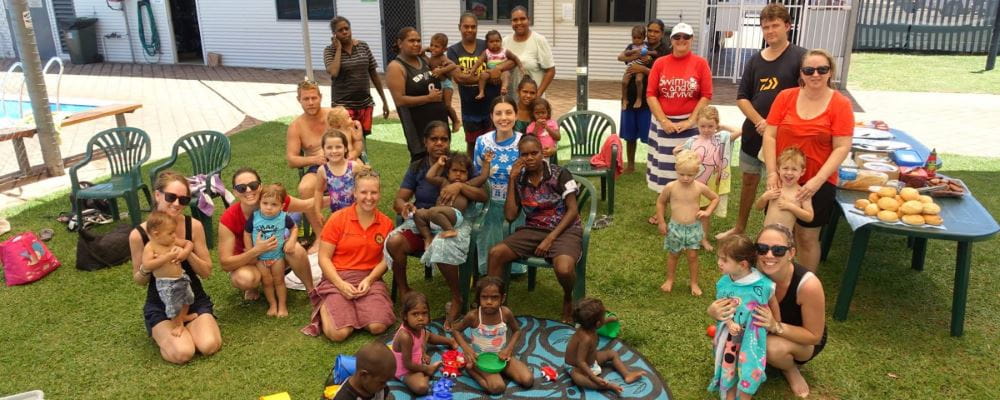 A group of mums and babies on the grass at Fitzroy Crossing Pool