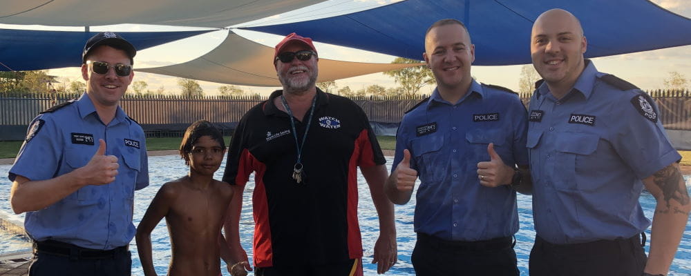 Police officers with a local Aboriginal boy and Pool Manager Trevor Caporn by the Fitzroy Remote Pool