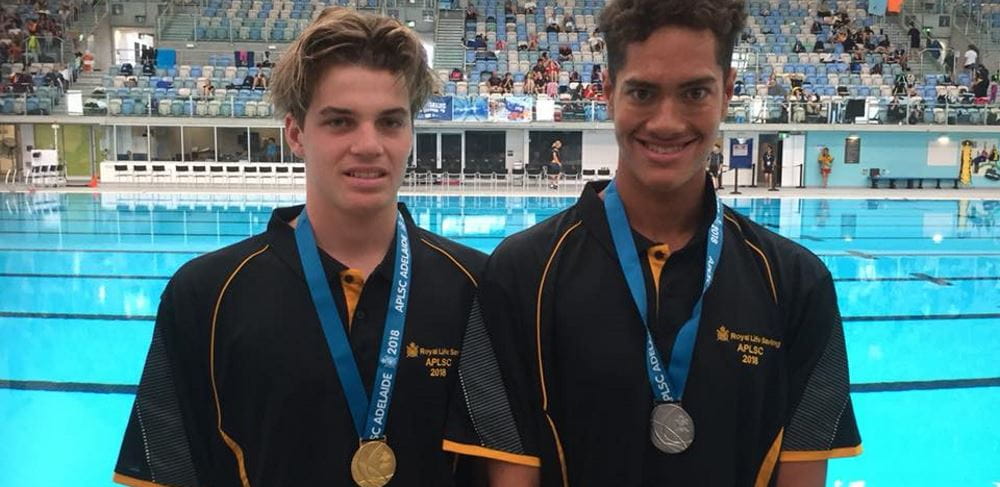 Harrison Hynes and TJ CHong Sue by the pool with their medals in Adelaide