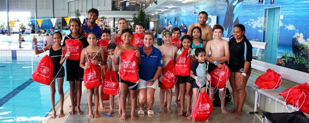 A group of children and adults with Swim and Survive bags by the pool at Goldfields Oasis