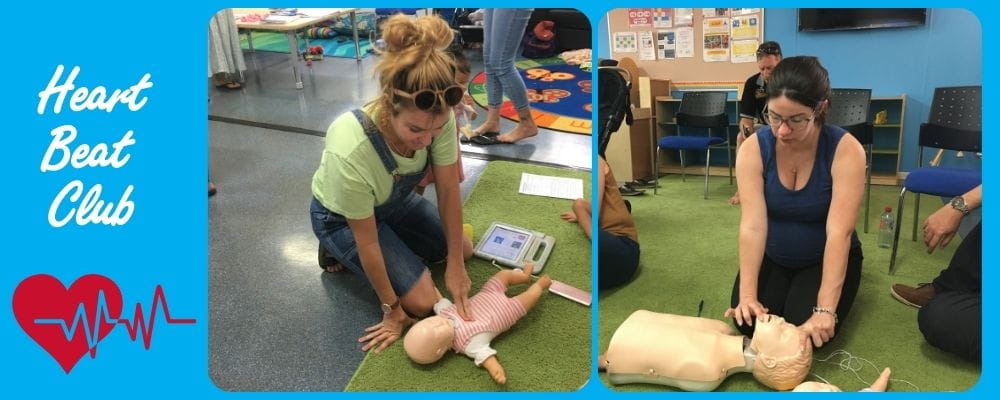 Parents practising CPR skills on baby and child manikins