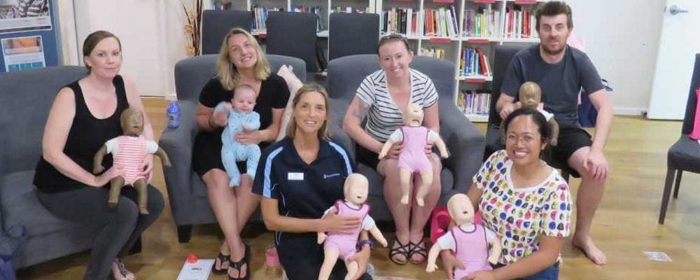A group of Port Hedland parents with RLSSWA's Jacqui Forbes holding baby manikins