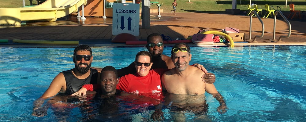 Four multicultural men with their swimming instructor