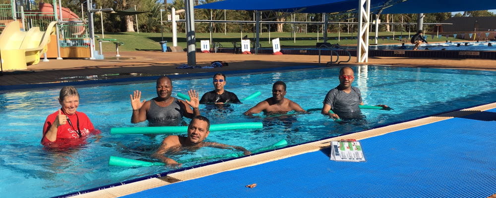 Multicultural men in the pool with their swim instructor at South Hedland Aquatic Centre