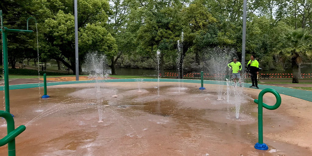 Two maintenance workers inspecting hyde park splash pad