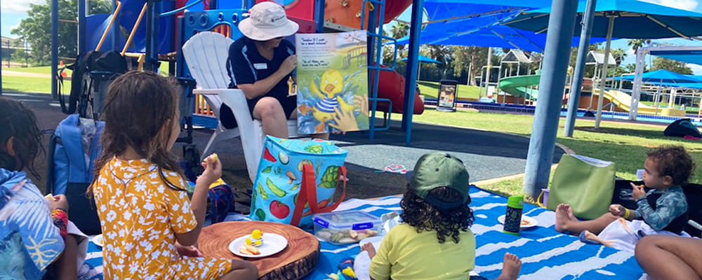 young Aboriginal children being read a water safety story book