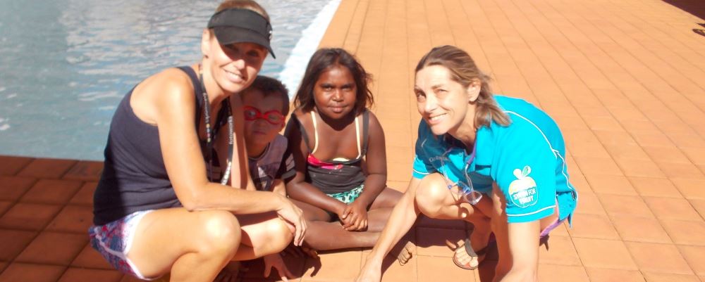 Leisa and Jacqui with two aboriginal children by the pool at Yandeyarra