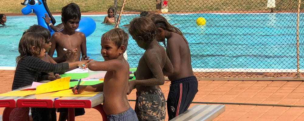 Aboriginal children at Jigalong playing by the water of the pool