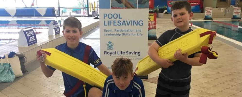 Three boys with lifesaving rescue tubes by the pool at Goldfields Oasis Leisure Centre