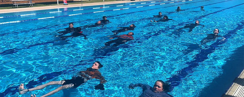 Students swimming on their back in the pool at Kambalda