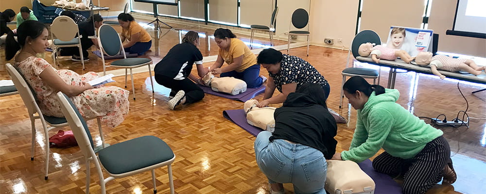 Parents practising CPR as part of a Heart Beat Club program