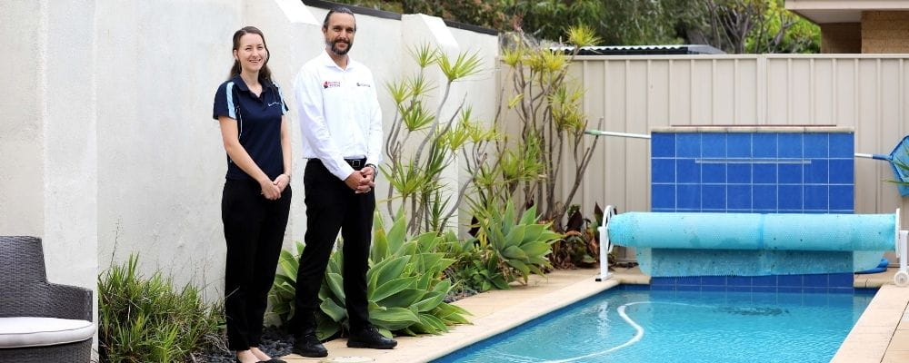 Royal Life Saving WA's Rachel Murray with Martin Roddis from Building and Energy, standing by a swimming pool