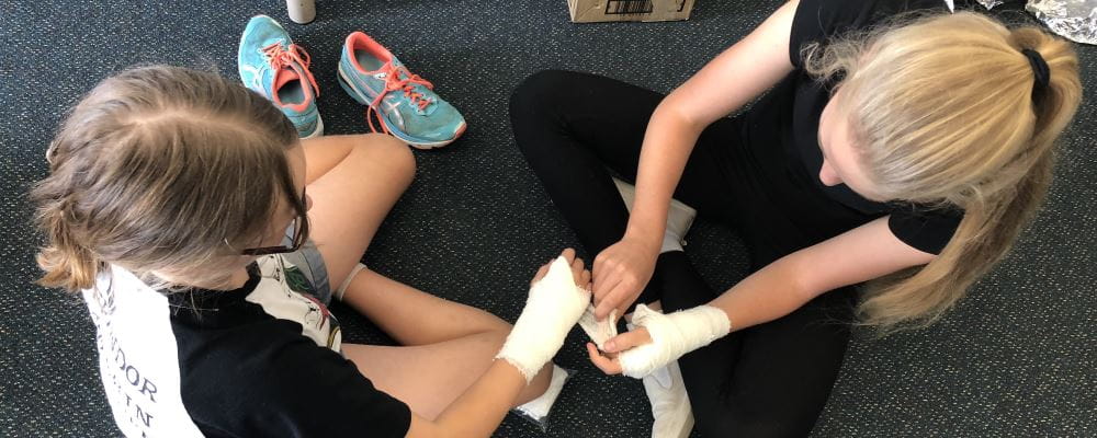 Two girls practising bandaging