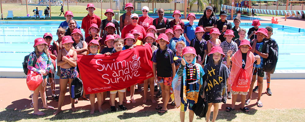 Goldfields children gathered by the pool at Leinster with Swim and Survive merchandise