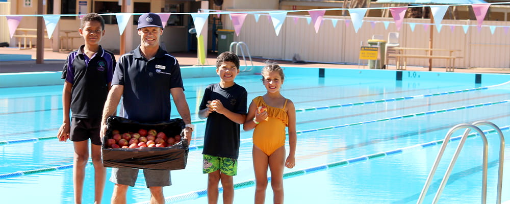Leinster Pool Manager Michael Plowman with three kids and a box of apples