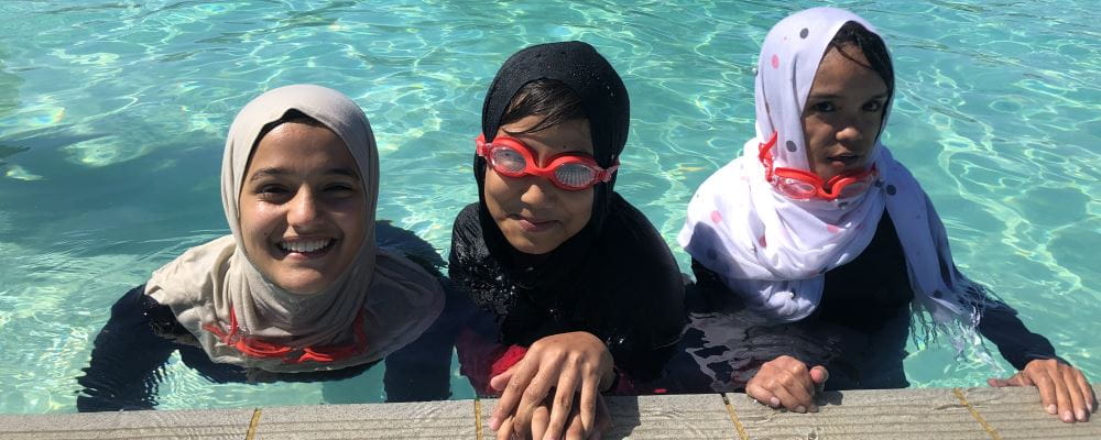 Three girls wearing Muslim headdress in the pool at Lynwood
