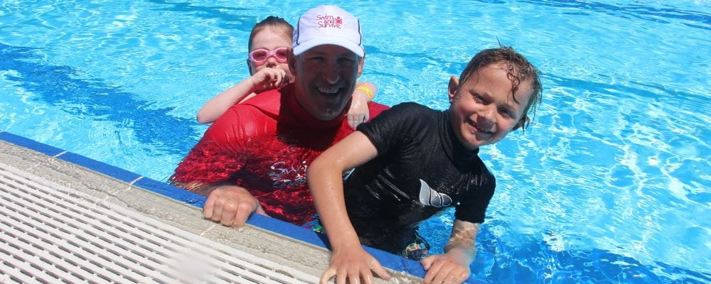 Matt Fuller with two children in the pool at Beatty Park