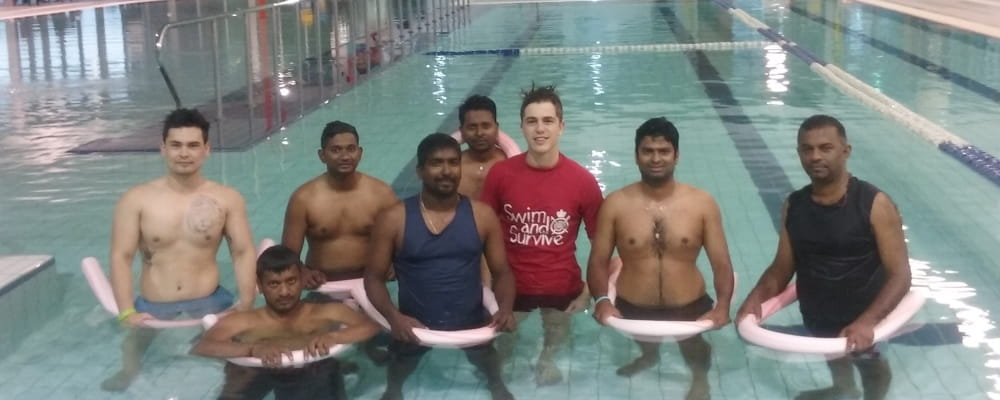 7 men and a swim instructor in the water at Cannington Leisureplex
