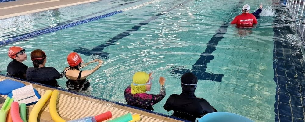 Multicultural women in the pool with their instructor