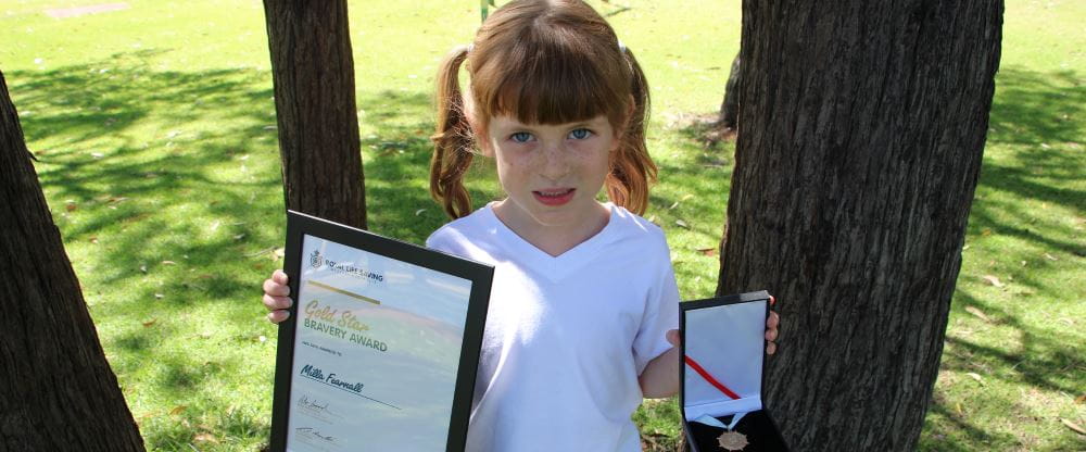 Milla Fearnall with her Bravery Award certificate and medal