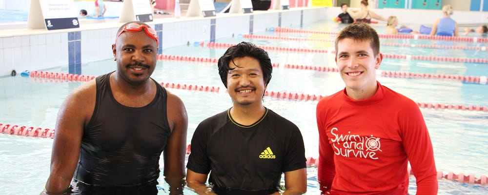 Multicultural men with their swimming instructor at a pool