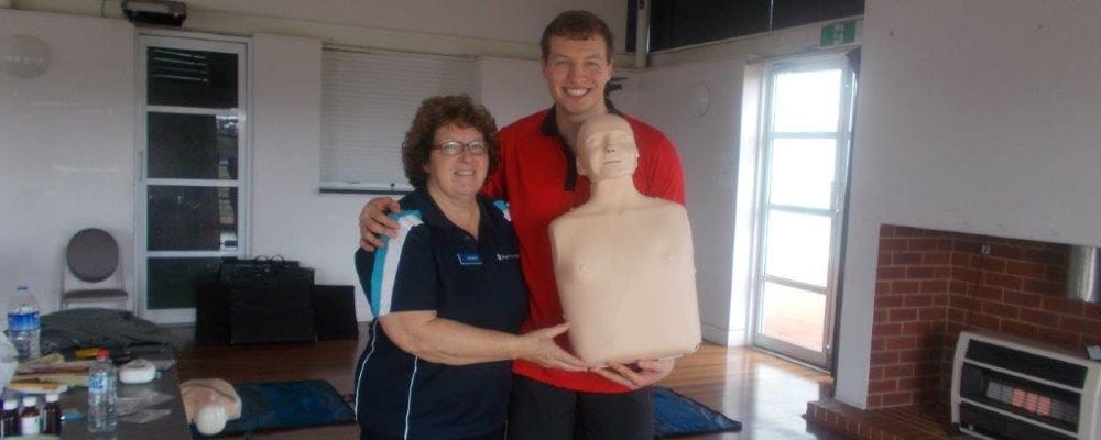 Royal Life Saving community trainer Marion, with Sam Kempton from YMCA holding a CPR manikin