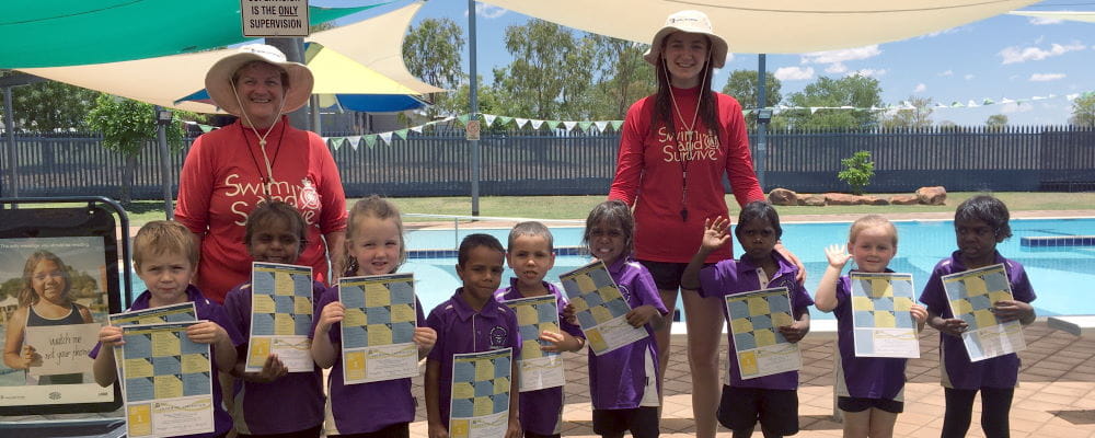 Adele Caporn and Niamh Hurley with Fitzroy Crossing children holding their swimming certificates